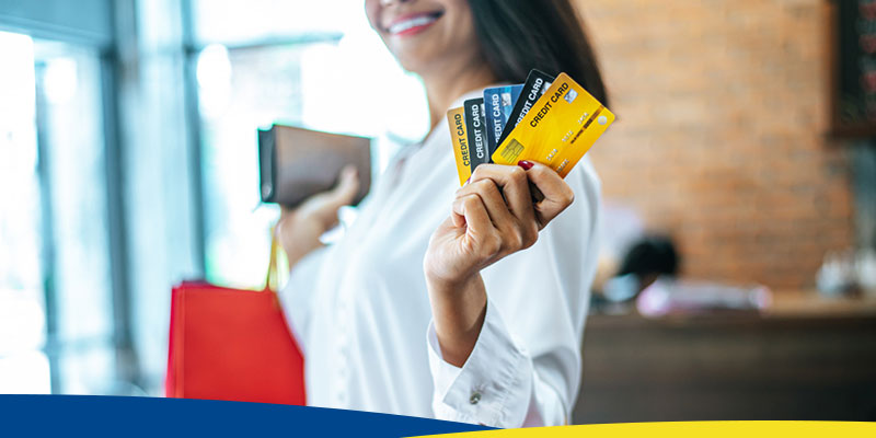 Mulher, jovem, fazendo compras com vários cartões de crédito