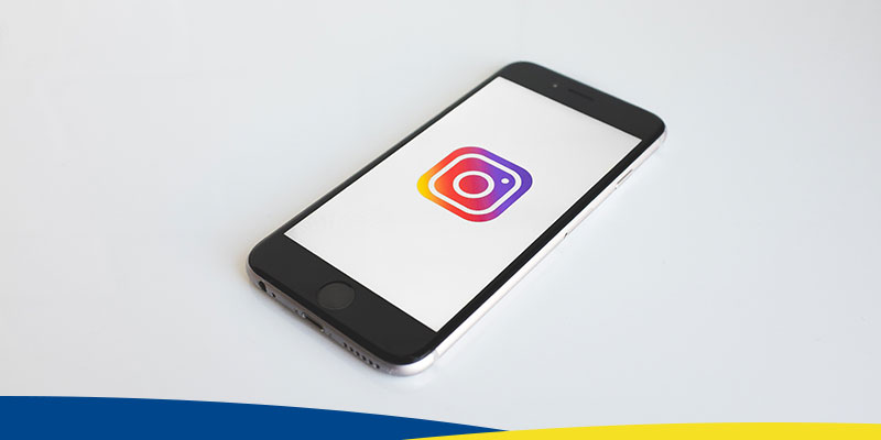 Celular, em fundo branco, mostrando logotipo do Instagram