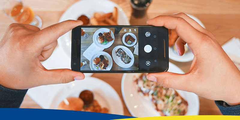 Pessoa tirando fotos de alimentos com um celular